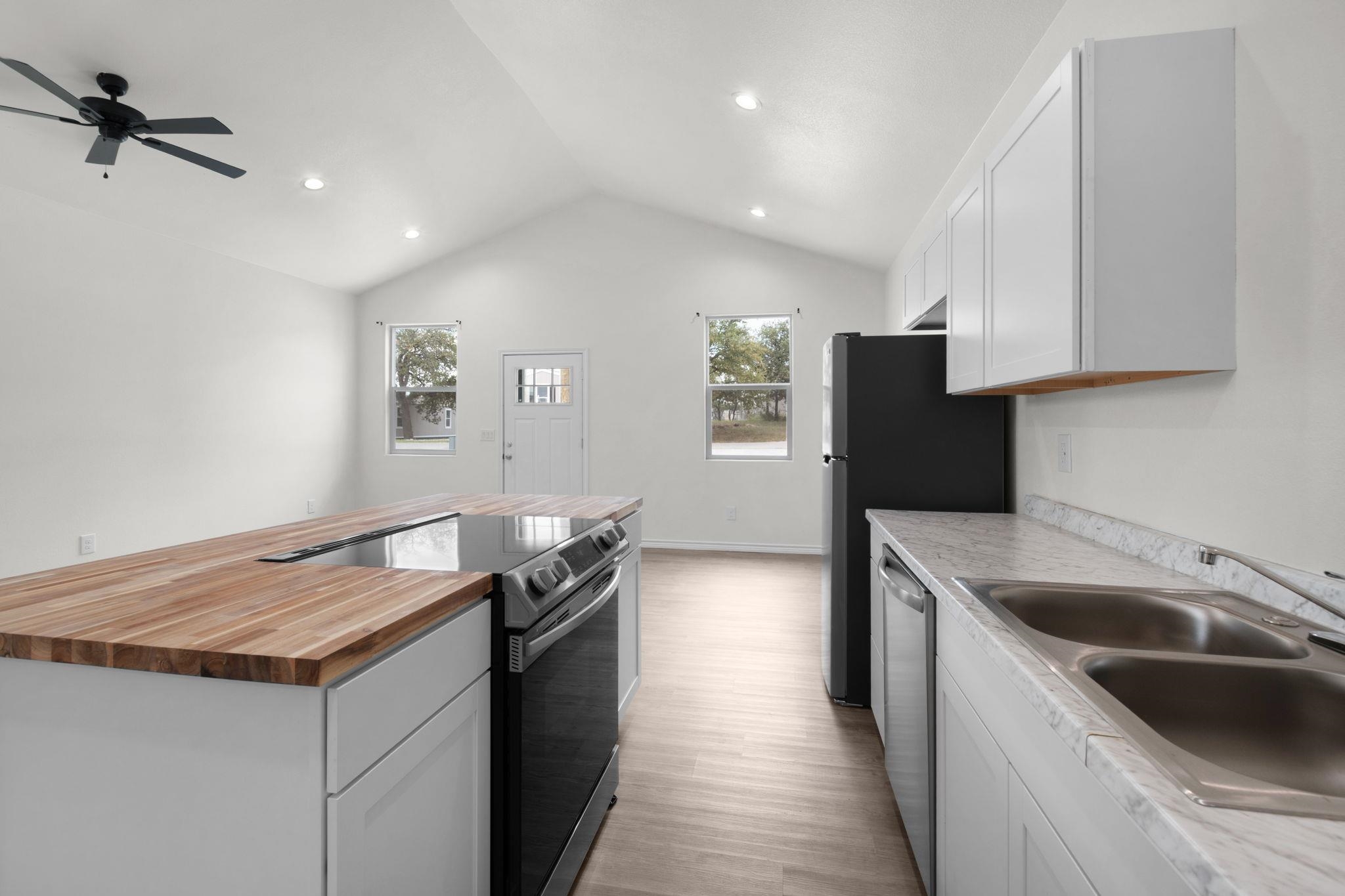 870 Waco Street Kingsland, TX 78639 - Photo 14 of 30 a kitchen that has a sink and a stove in it