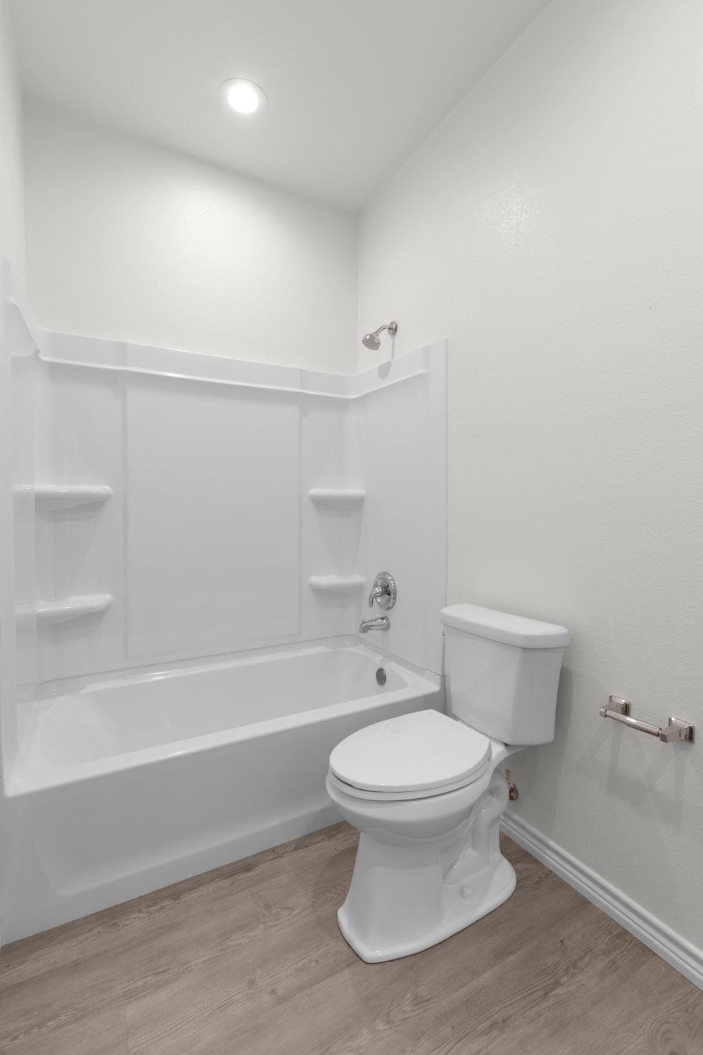 870 Waco Street Kingsland, TX 78639 - Photo 23 of 30 a bathroom with a toilet and a bathtub