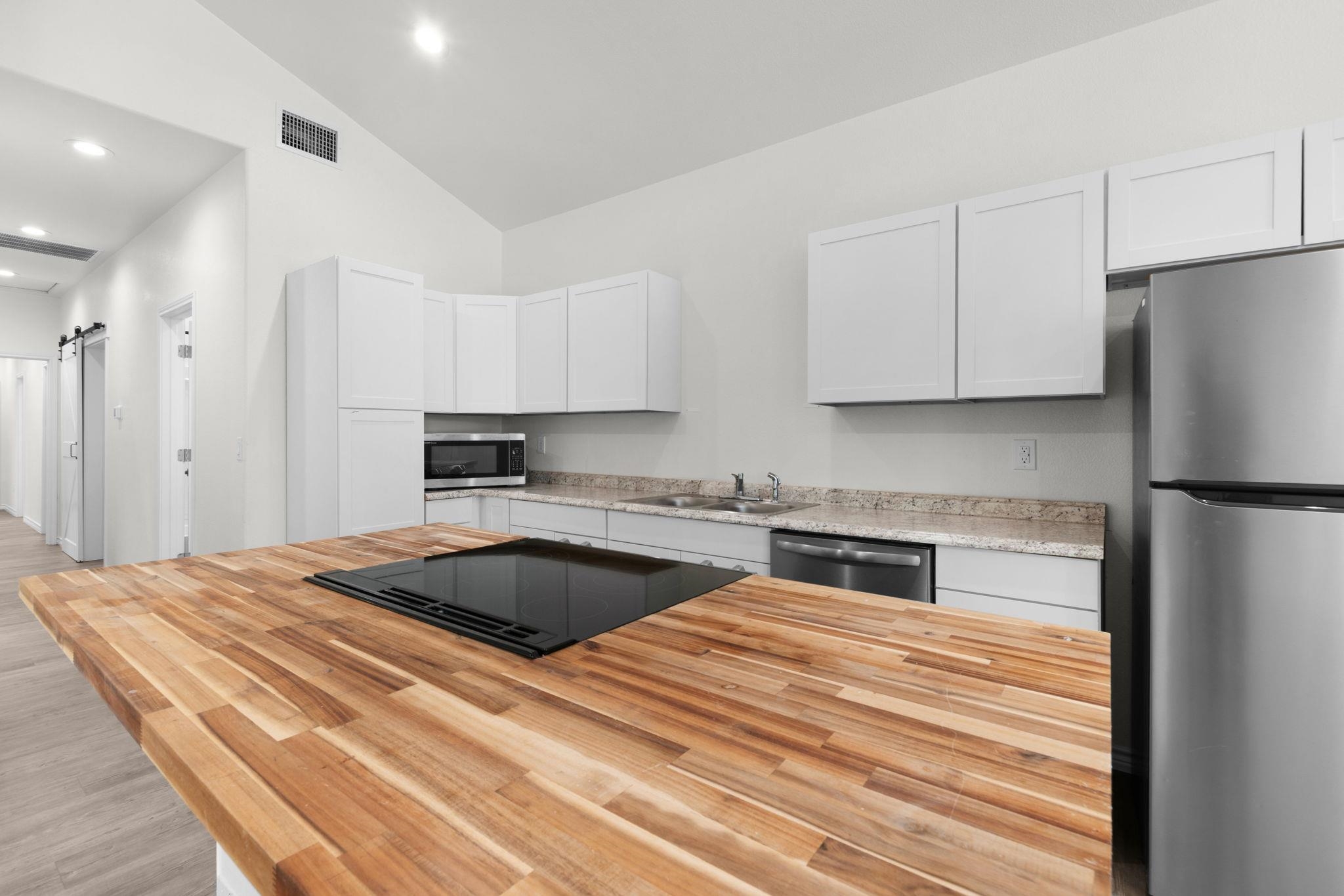 870 Waco Street Kingsland, TX 78639 - Photo 8 of 30 a kitchen with granite countertop a refrigerator sink and cabinets