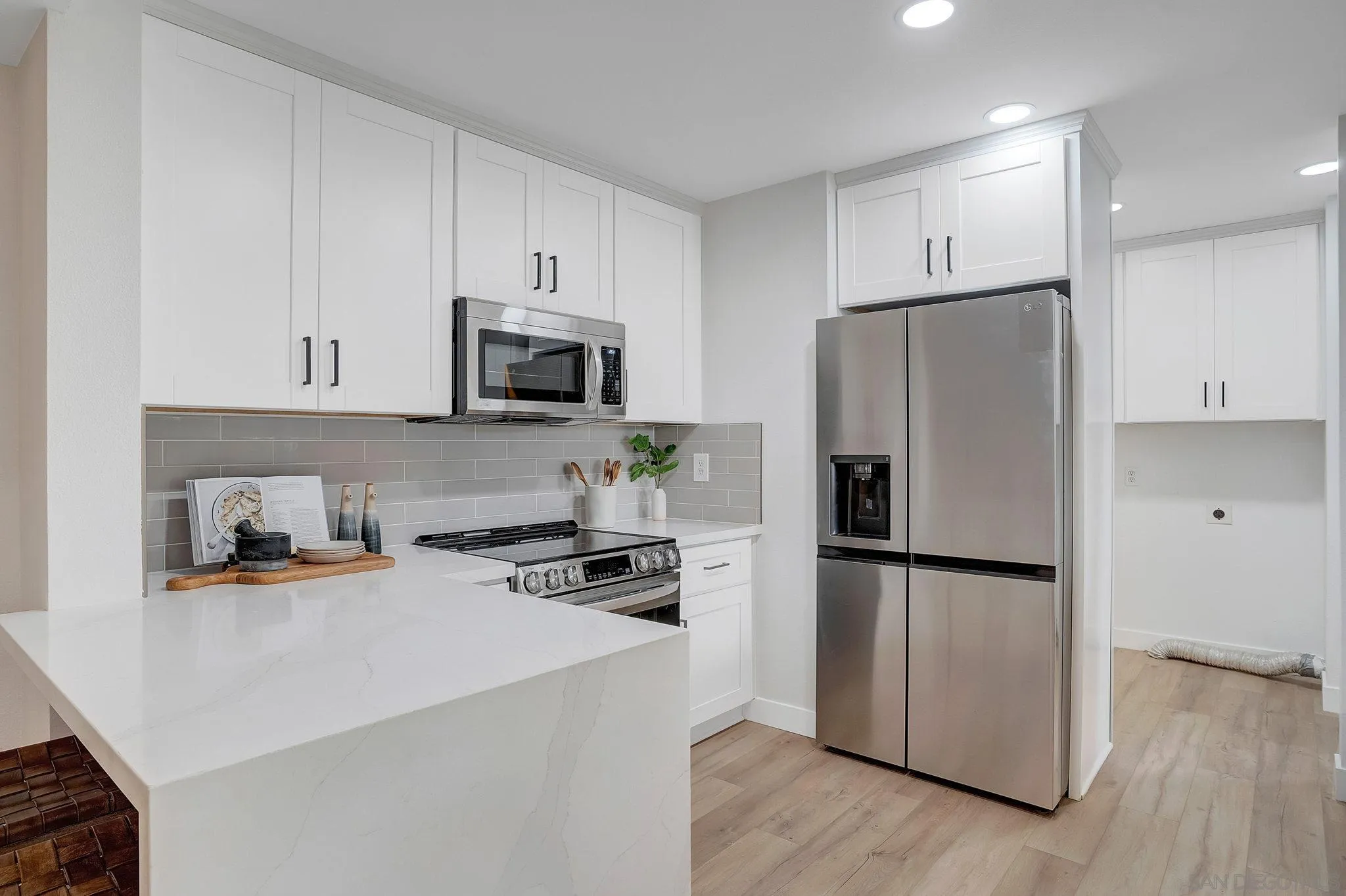 1344 Caminito Septimo Cardiff, CA 92007 - Photo 10 of 10 a kitchen with a refrigerator a stove top oven a sink and cabinets