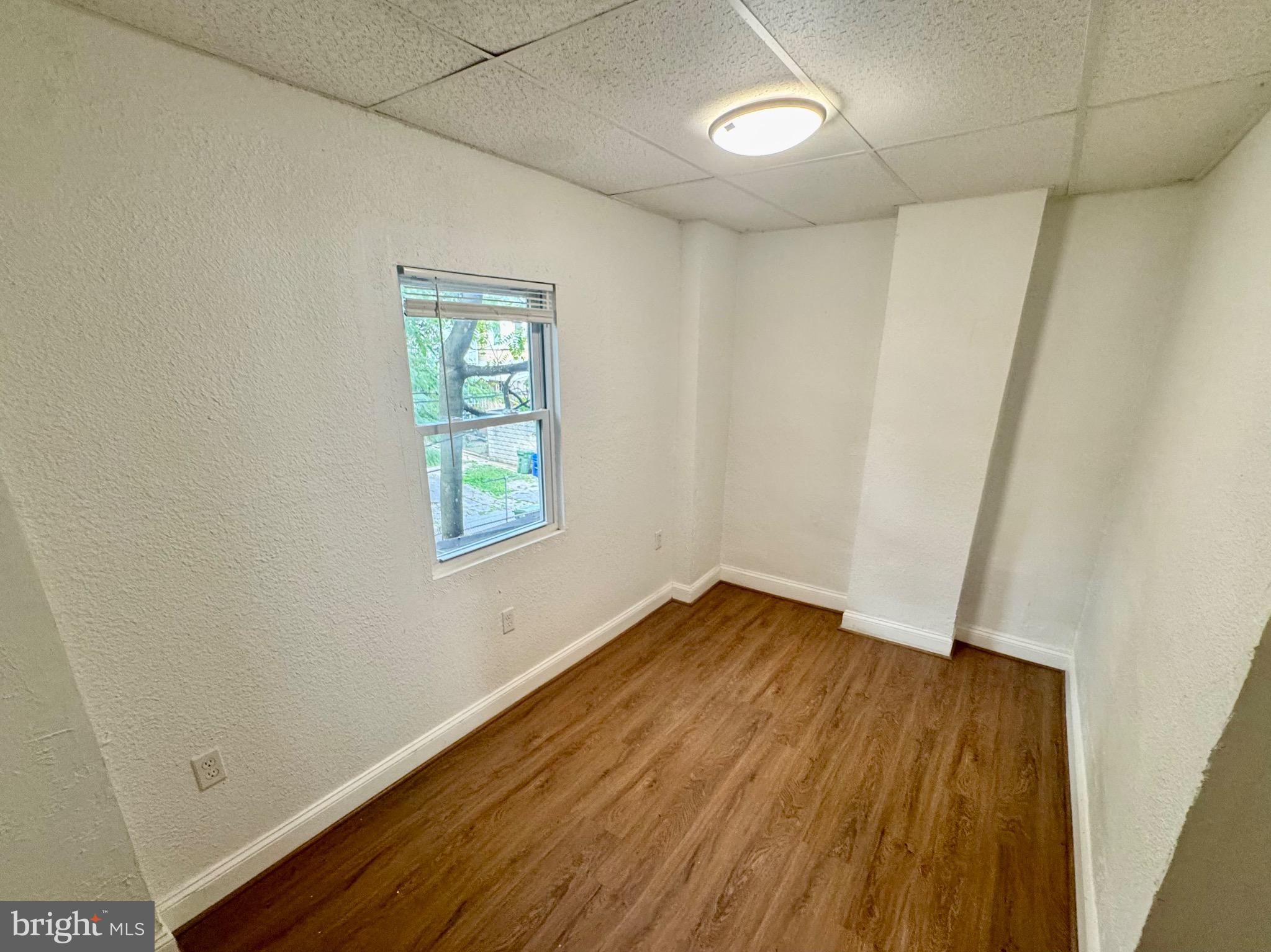 2012 Cliftwood Avenue Baltimore, MD 21213 - Photo 17 of 25 an empty room with wooden floor and windows