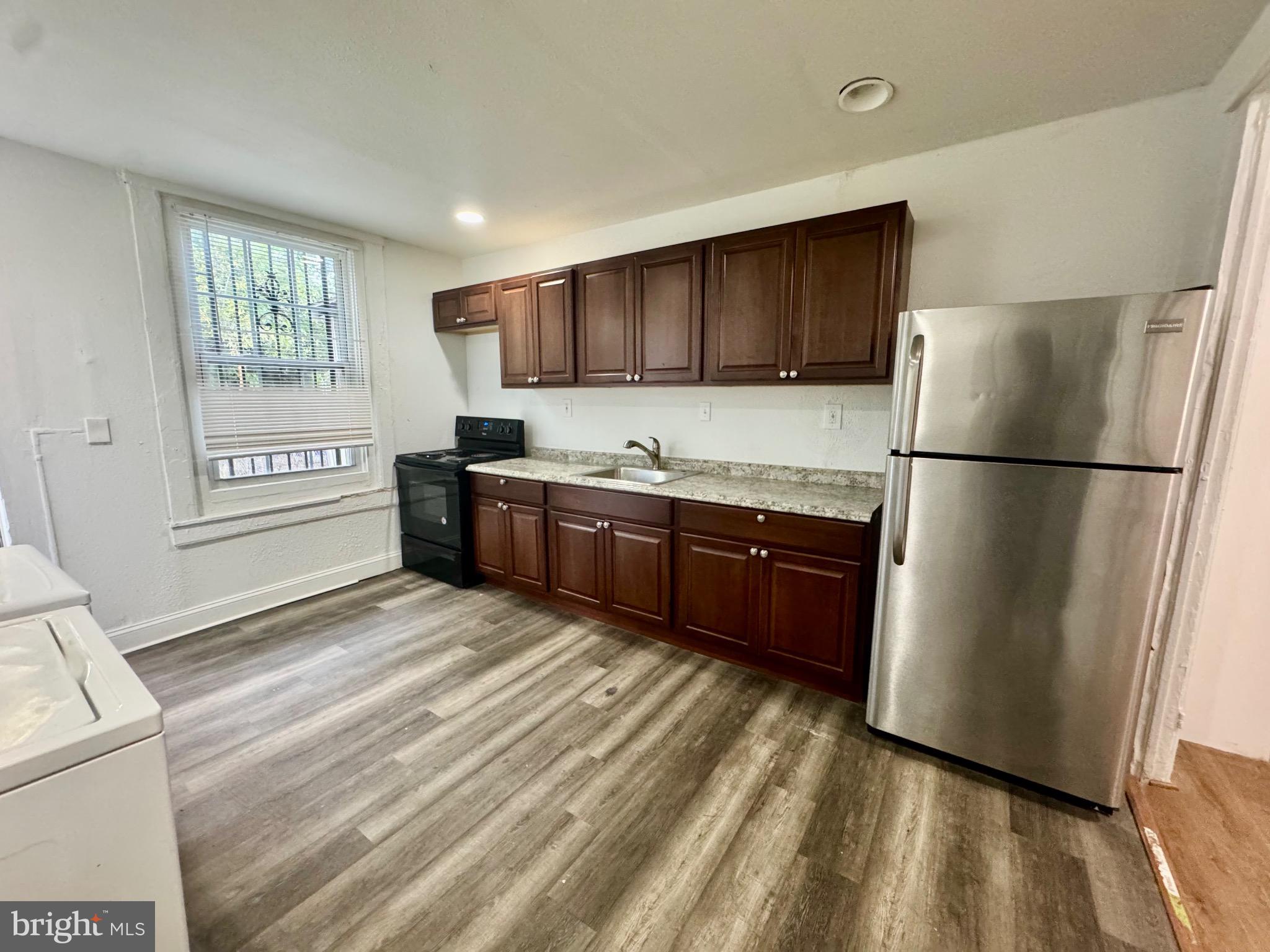 2012 Cliftwood Avenue Baltimore, MD 21213 - Photo 2 of 25 a kitchen with stainless steel appliances granite countertop a refrigerator sink and wooden cabinets