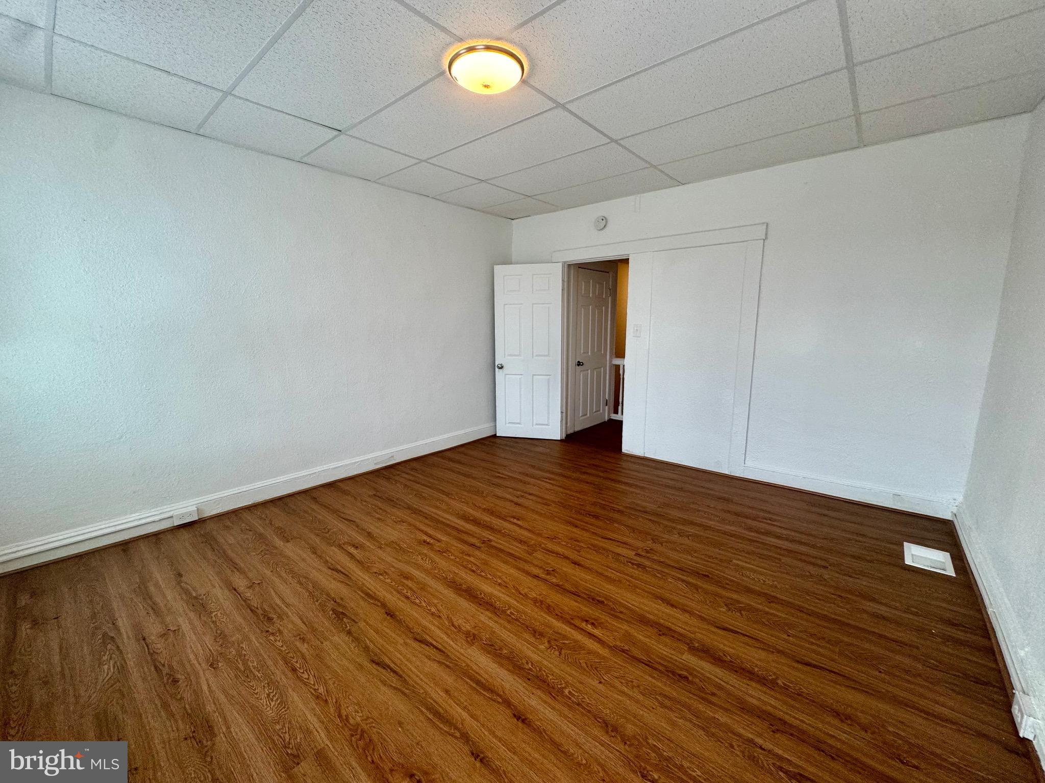 2012 Cliftwood Avenue Baltimore, MD 21213 - Photo 23 of 25 a view of an empty room with wooden floor and a window