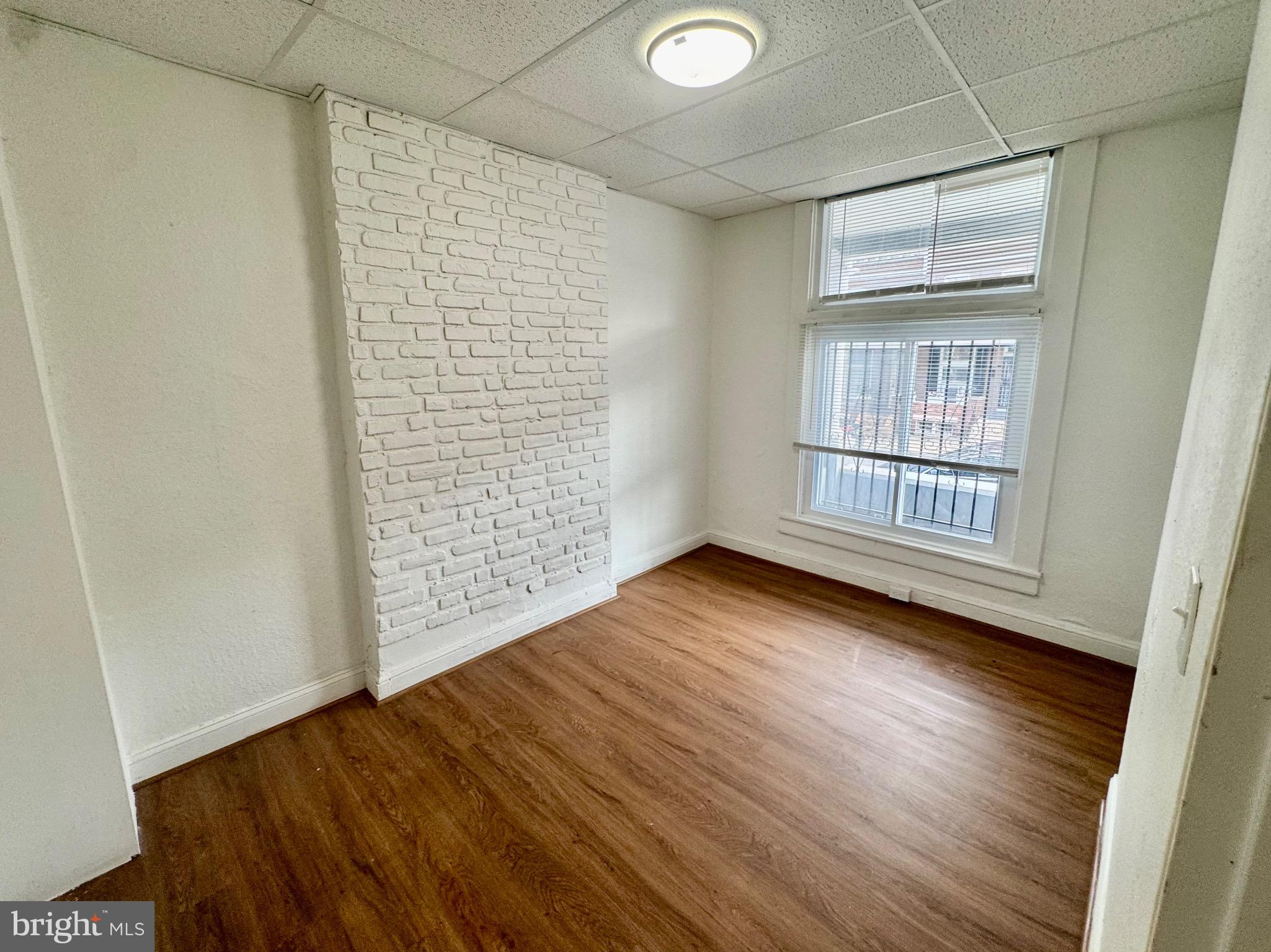 2012 Cliftwood Avenue Baltimore, MD 21213 - Photo 4 of 25 an empty room with wooden floor and windows