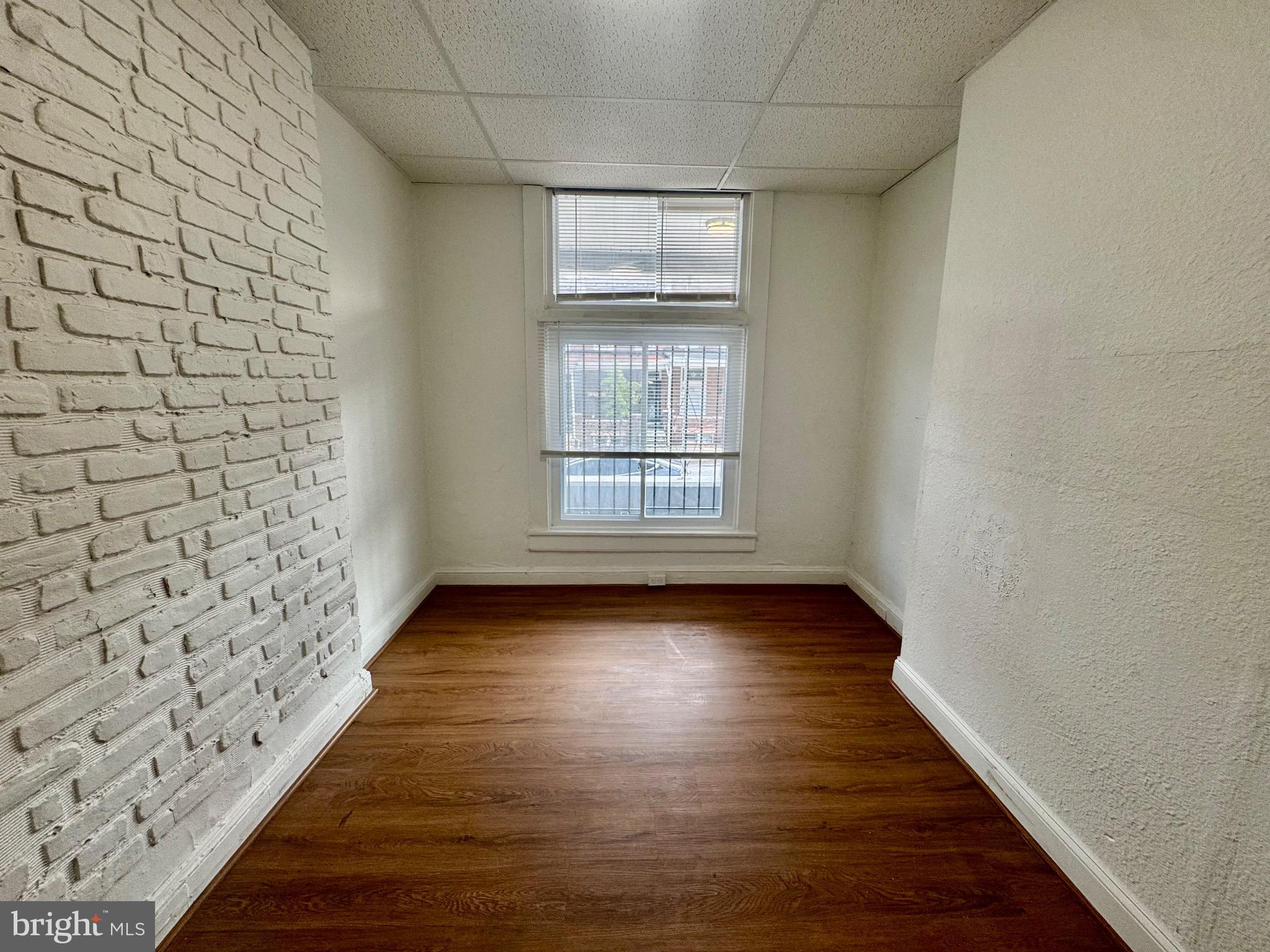 2012 Cliftwood Avenue Baltimore, MD 21213 - Photo 6 of 25 a view of an empty room with wooden floor and window