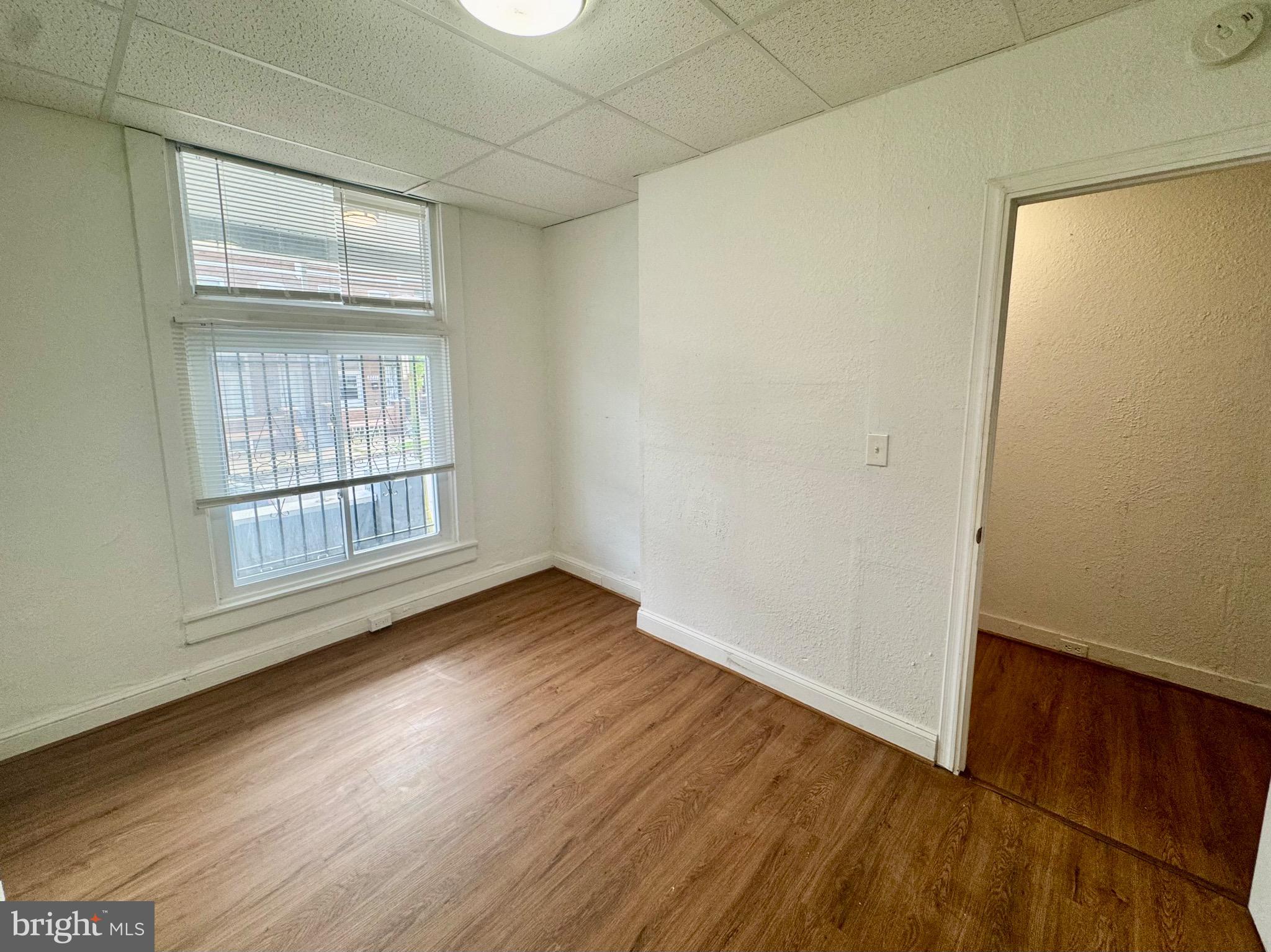 2012 Cliftwood Avenue Baltimore, MD 21213 - Photo 7 of 25 an empty room with wooden floor and windows
