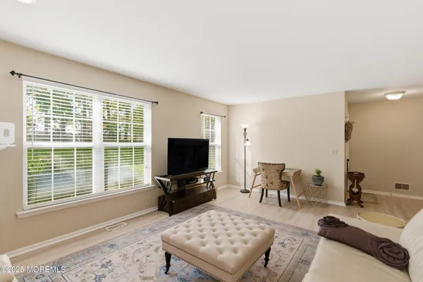 a living room with furniture a flat screen tv and a window