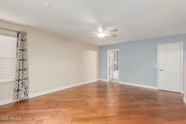 a view of an empty room with chandelier fan