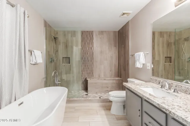 a bathroom with a granite countertop sink toilet and shower