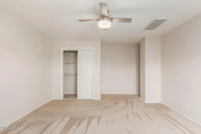 a view of a room with a ceiling fan and hardwood floor