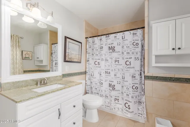 a bathroom with a granite countertop sink a toilet and a shower