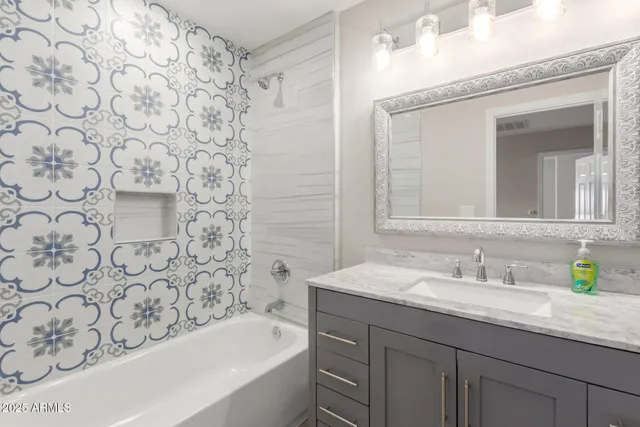 a bathroom with a granite countertop sink and a bathtub