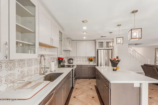 a kitchen that has a lot of cabinets a sink and a stove in it