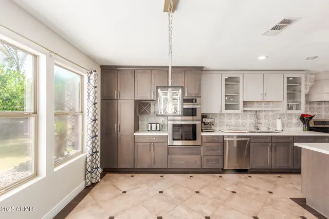 a kitchen with stainless steel appliances granite countertop a stove a sink and a refrigerator