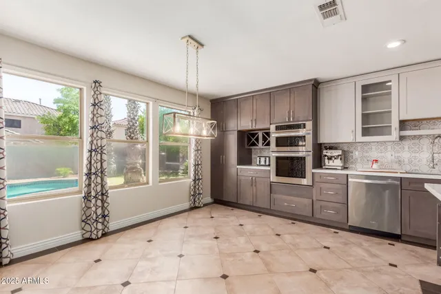 a kitchen with stainless steel appliances granite countertop a refrigerator and a stove top oven