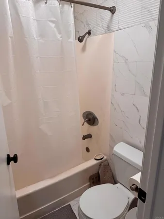 a white toilet and tub sitting next to a bathroom sink