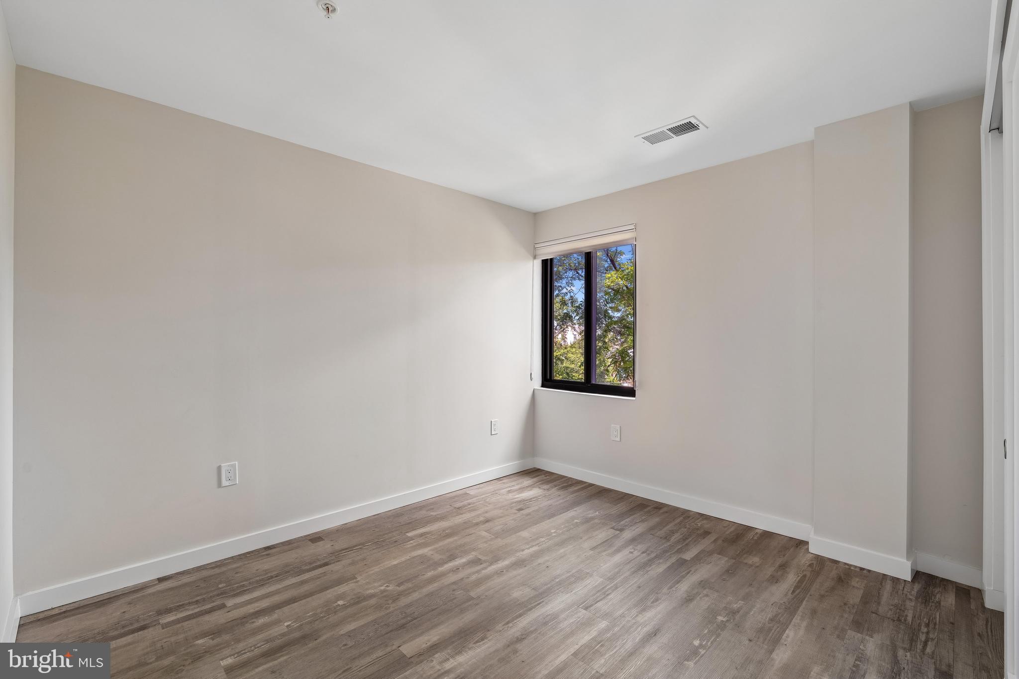 700 Roeder Road, Unit 401 Silver Spring, MD 20910 - Photo 20 of 30 a view of an empty room with wooden floor and a window