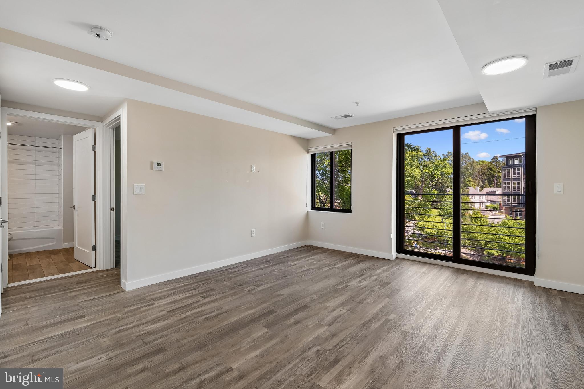 700 Roeder Road, Unit 401 Silver Spring, MD 20910 - Photo 8 of 30 an empty room with wooden floor and windows