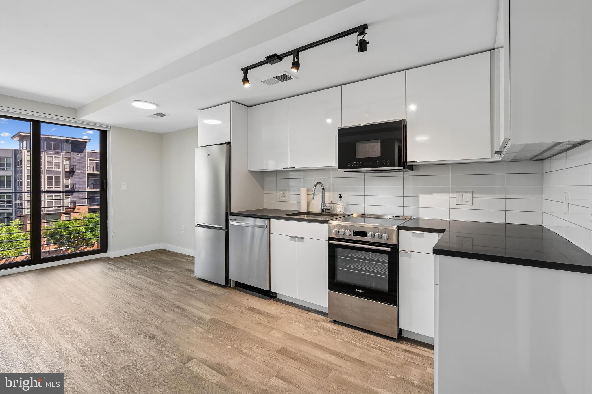 700 Roeder Road, Unit 401 Silver Spring, MD 20910 - Photo 10 of 30 a kitchen with stainless steel appliances granite countertop a stove and a sink
