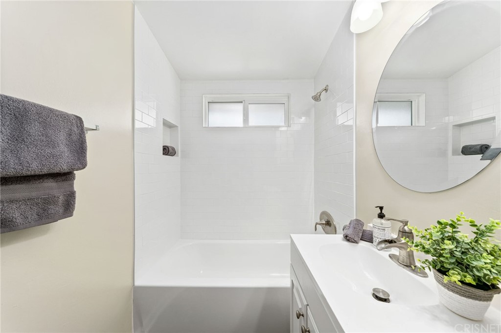 6737 Delco Avenue Winnetka, CA 91306 - Photo 24 of 31 a bathroom with a tub sink and mirror