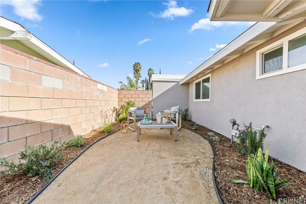 6737 Delco Avenue Winnetka, CA 91306 - Photo 30 of 31 a view of a patio with table and chairs and potted plants