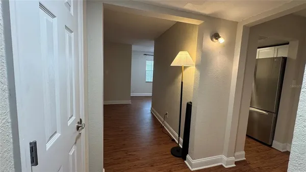 a view of a hallway with wooden floor and staircase