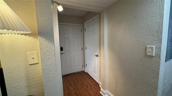 a view of a hallway with wooden floor and staircase