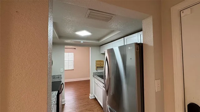 a view of a refrigerator in kitchen and wooden floor
