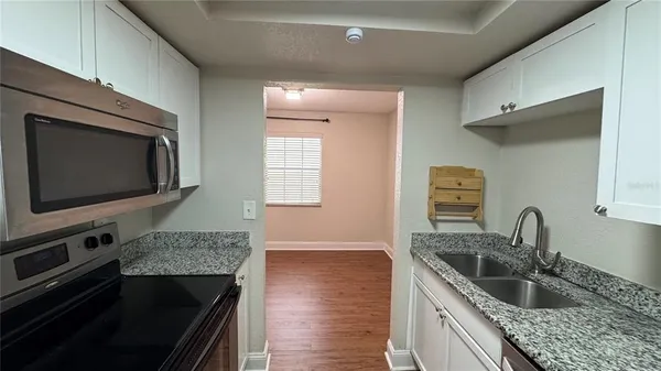 a kitchen with granite countertop a sink and a stove top oven