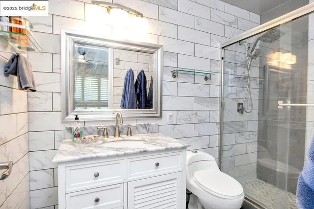 a bathroom with a granite countertop sink a toilet and shower