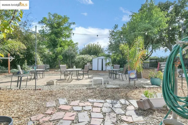 a view of house with backyard and sitting area