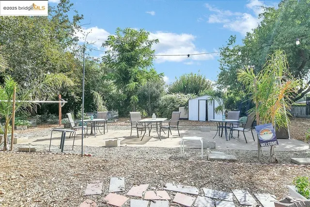 a view of house with backyard and sitting area