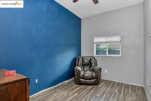 a view of a livingroom with wooden floor and a ceiling fan