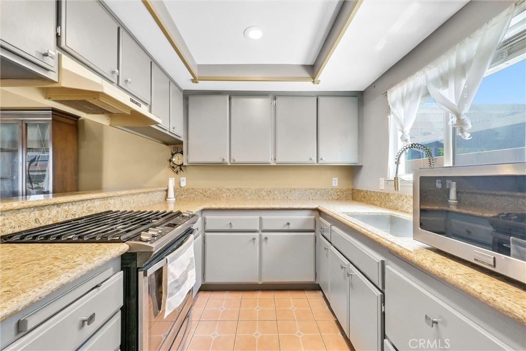 3415 Siskiyou Circle Riverside, CA 92503 - Photo 12 of 41 a kitchen with stainless steel appliances granite countertop a sink stove and cabinets