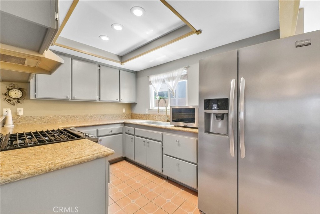 3415 Siskiyou Circle Riverside, CA 92503 - Photo 9 of 41 a kitchen with kitchen island granite countertop a sink stove and refrigerator