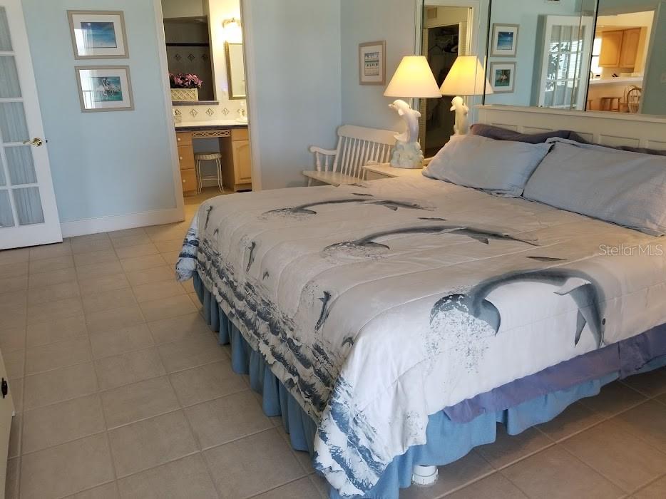 13650 Gulf Boulevard, Unit 304 Madeira Beach, FL 33708 - Photo 35 of 63 a bedroom with a bed and a chandelier