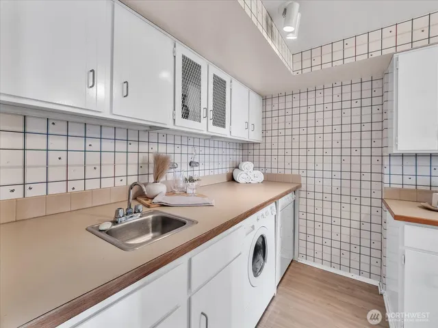 a bathroom with a sink a vanity and a blue shower