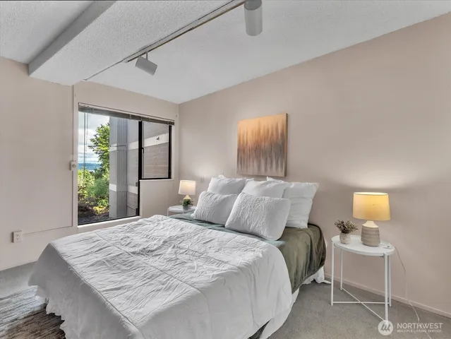 a bedroom with a bed and a lamp next to a window