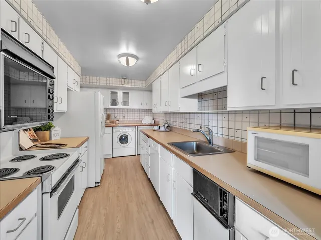 a kitchen with a sink stove top oven and refrigerator