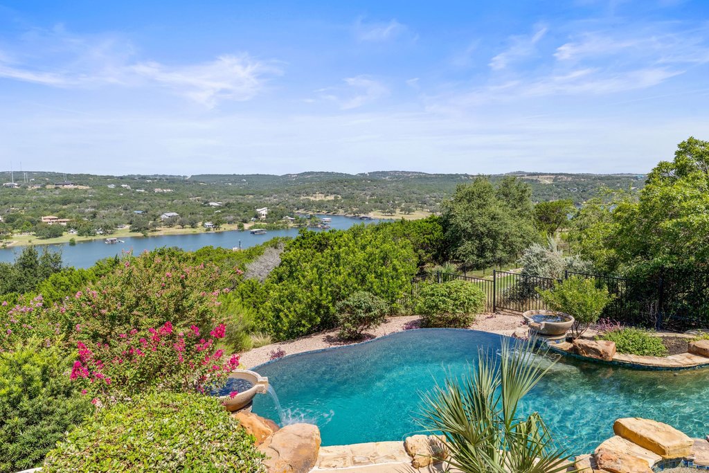 2702 Lakehurst Road Spicewood, TX 78669 - Photo 38 of 40 An inviting private pool area offers panoramic lake views surrounded by lush greenery.