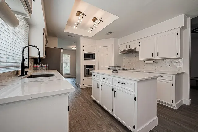 a kitchen with kitchen island a sink stainless steel appliances and cabinets