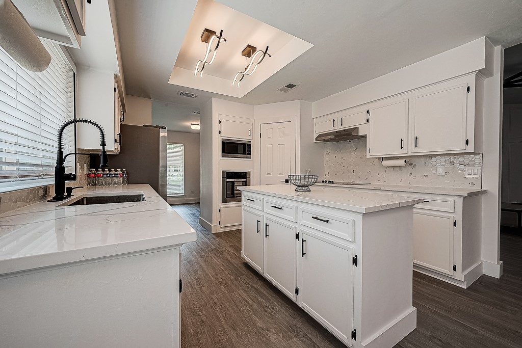 a kitchen with kitchen island a sink stainless steel appliances and cabinets