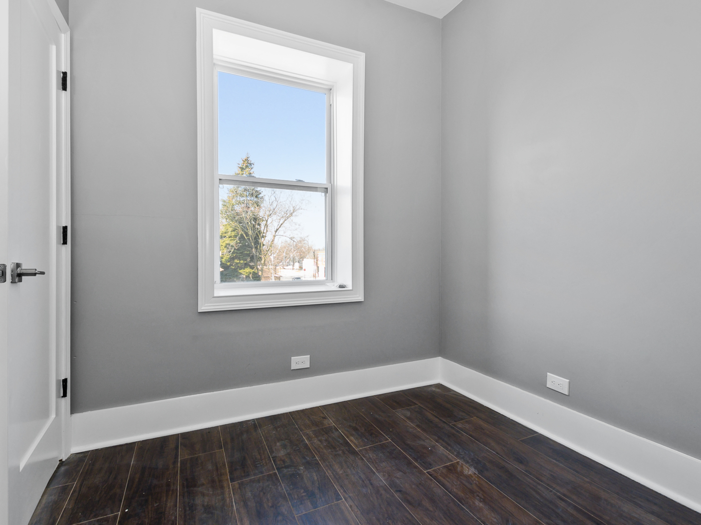 7305 South Sangamon Street Chicago, IL 60621 - Photo 22 of 29 a view of an empty room with wooden floor and a window