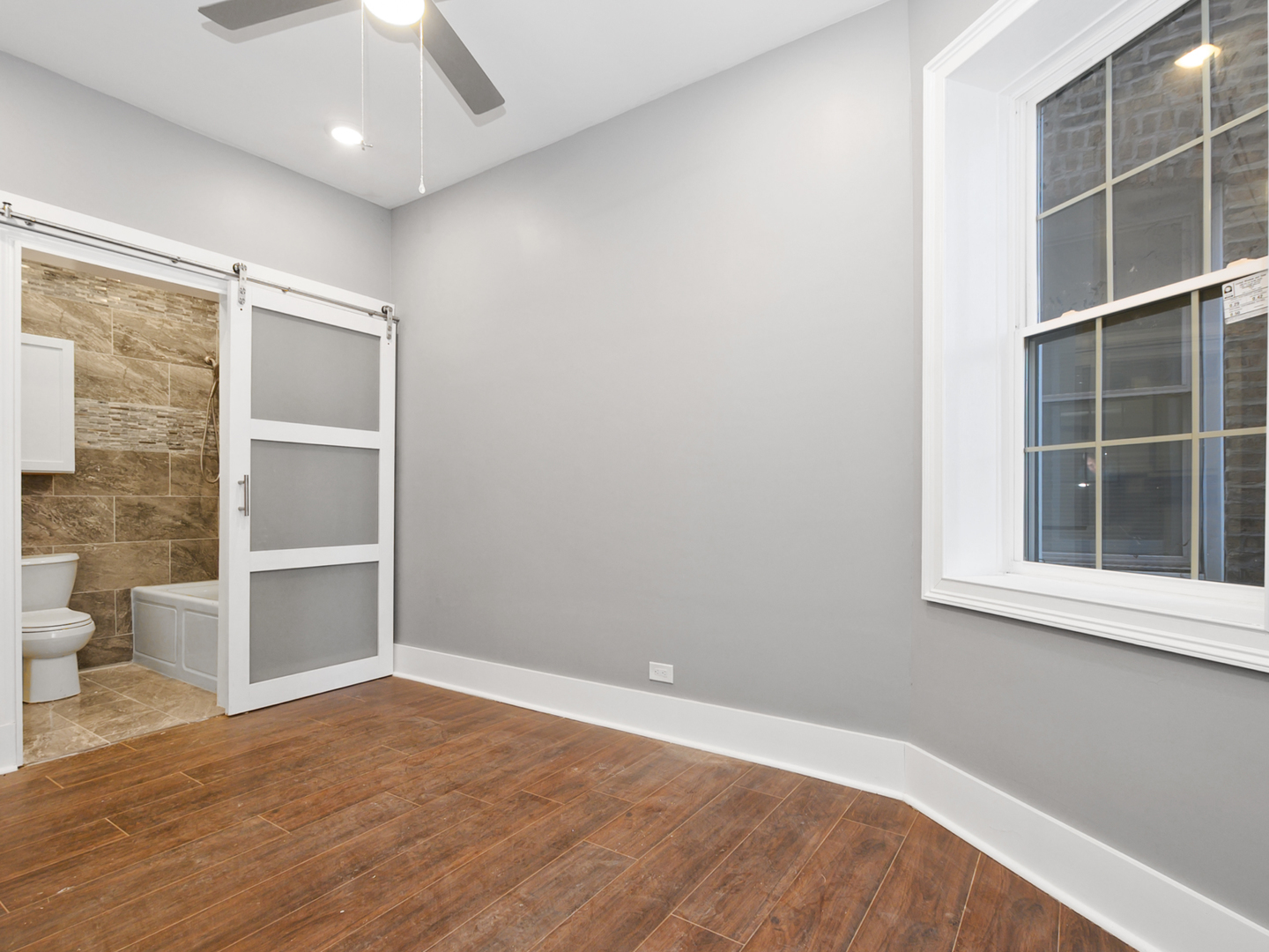 7305 South Sangamon Street Chicago, IL 60621 - Photo 6 of 29 a view of an empty room with a window and wooden floor