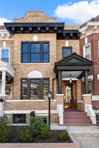 a front view of a building with a garden