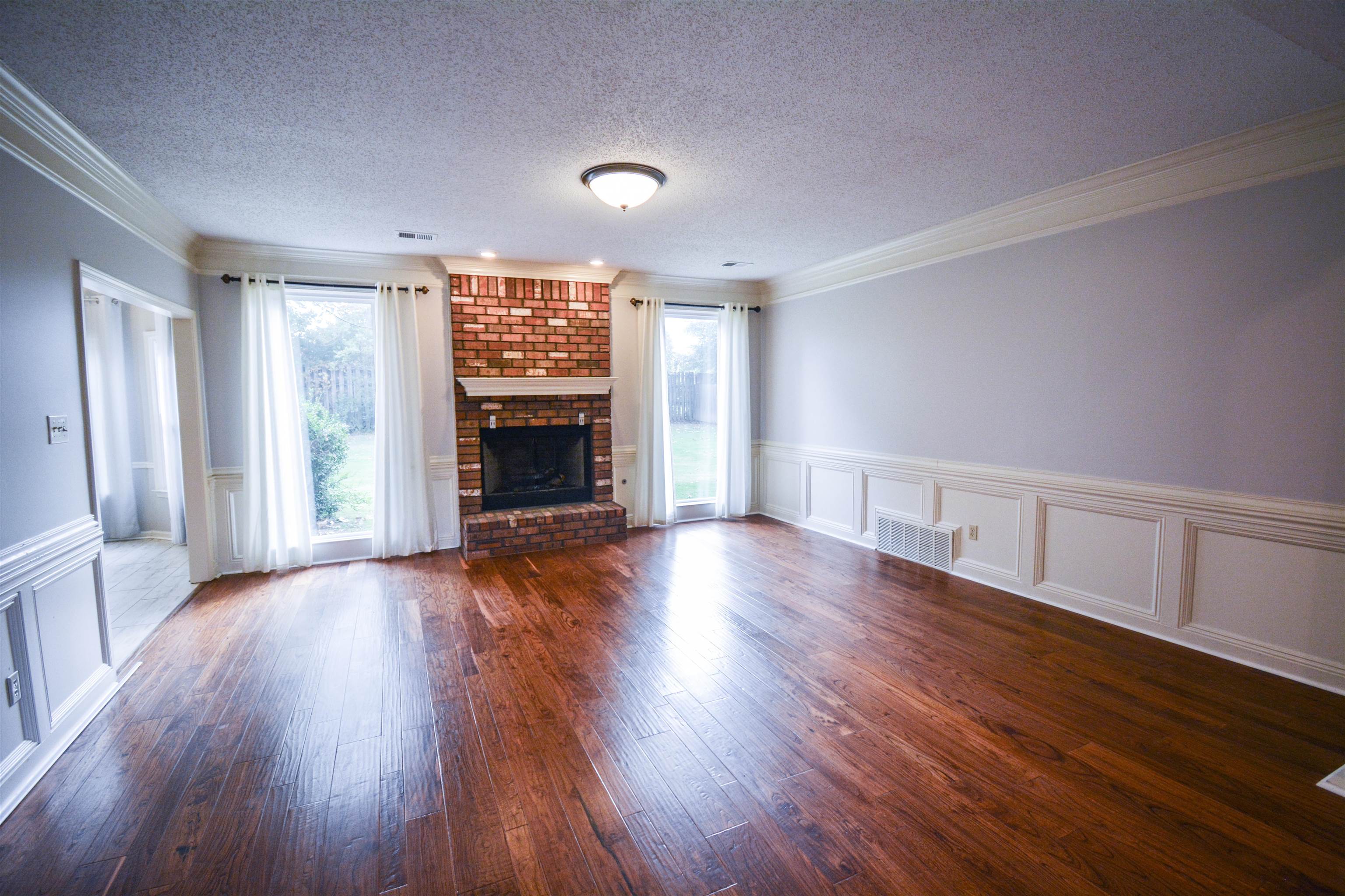 745 Roehampton Court Collierville, TN 38017 - Photo 21 of 40 an empty room with wooden floor fireplace and windows