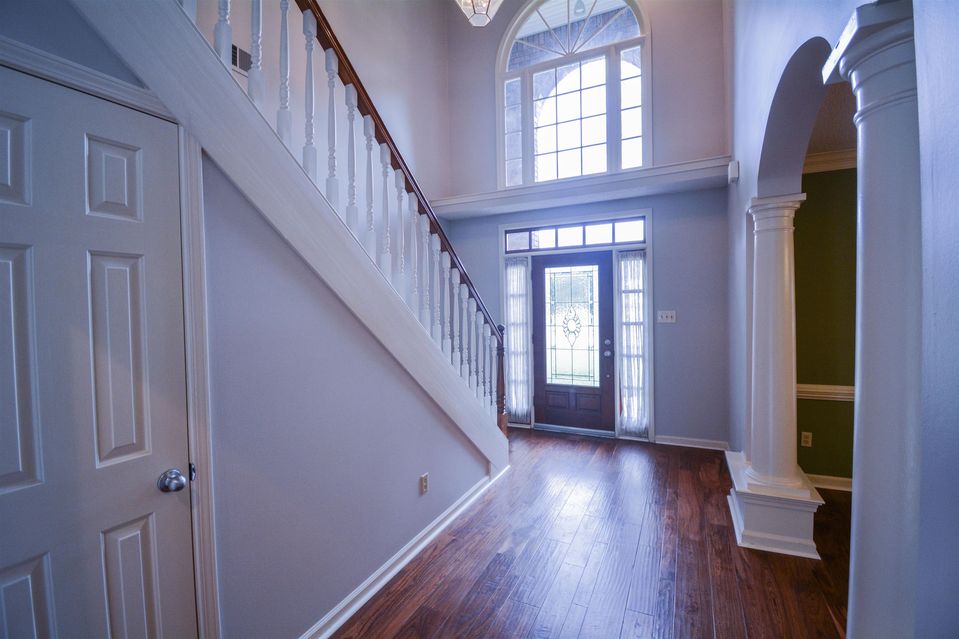 745 Roehampton Court Collierville, TN 38017 - Photo 24 of 40 Foyer featuring decorative columns, a high ceiling, dark wood-style flooring, arched walkways, and stairway