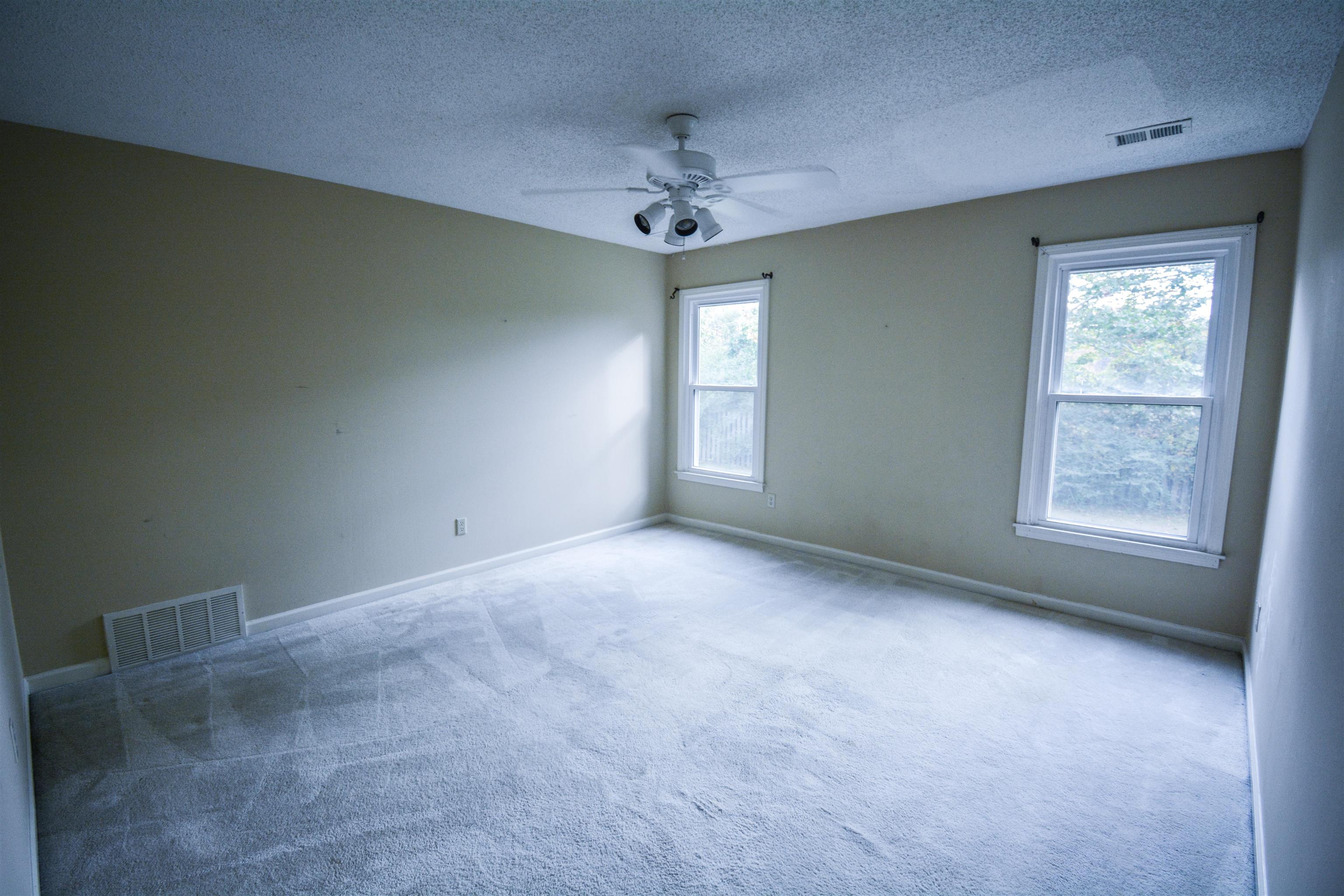 745 Roehampton Court Collierville, TN 38017 - Photo 26 of 40 an empty room with a chandelier fan and windows
