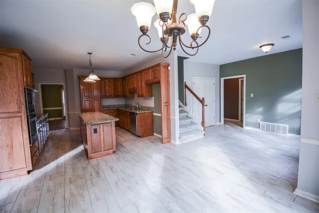 a view of a kitchen with granite countertop stainless steel appliances and wooden floor