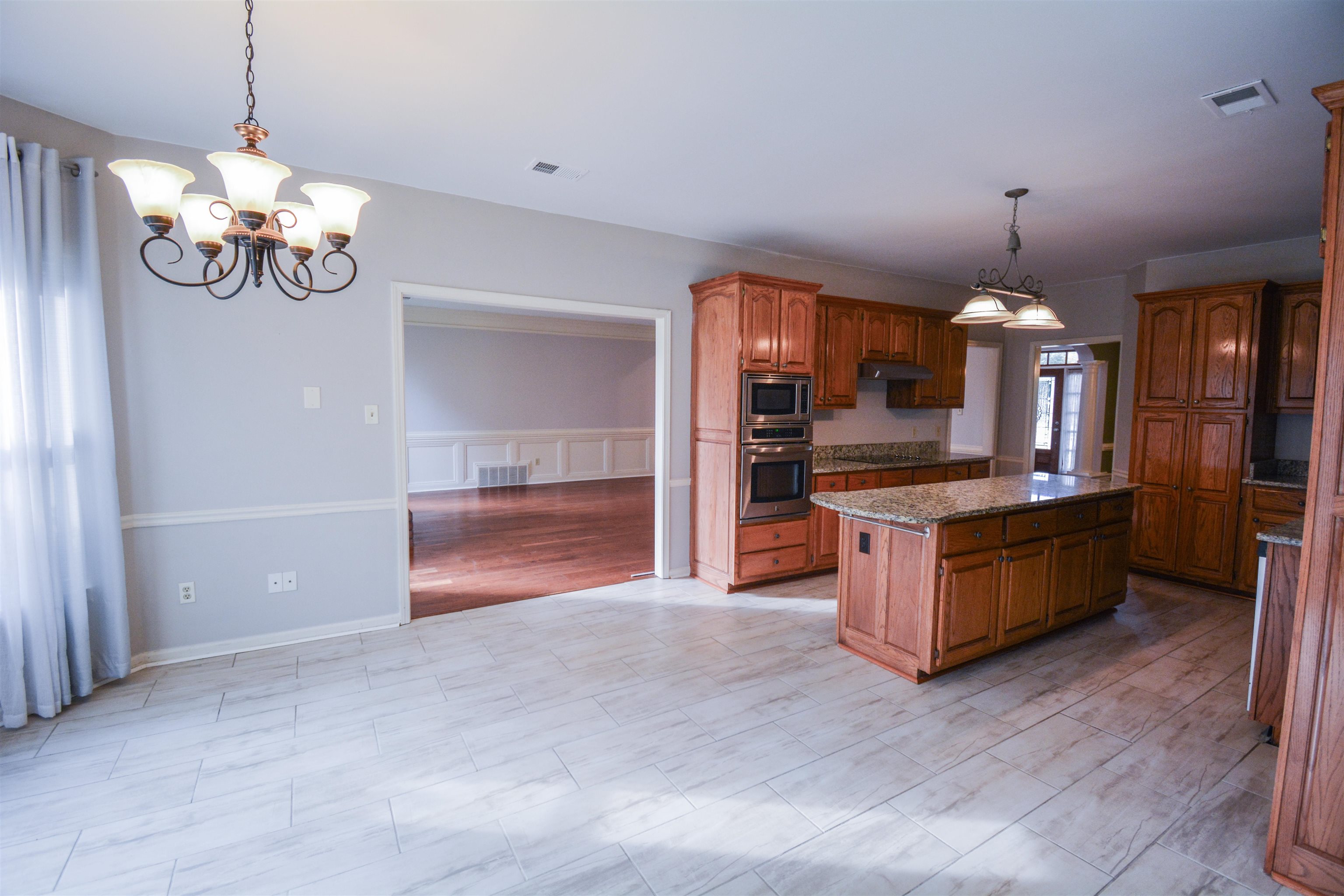 745 Roehampton Court Collierville, TN 38017 - Photo 7 of 40 a view of a kitchen with granite countertop stainless steel appliances and wooden floor